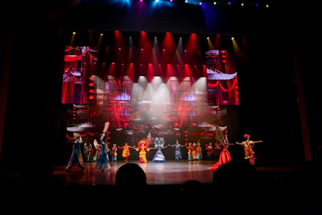 Performers on stage with colorful costumes and backdrop
